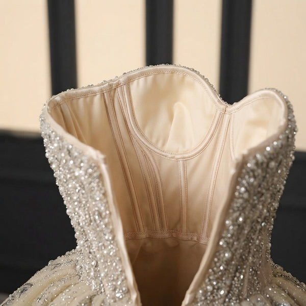 Close-up of the internal structural boning and detailed seams of a beaded wedding dress, showcasing precise tailoring.